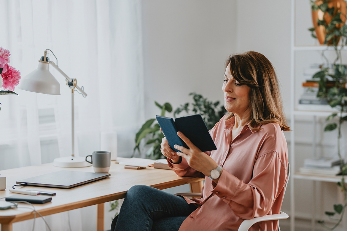 Businesswoman using weekly planner in her home office.